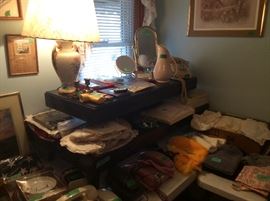 Vintage pictures on wall. Vintage coffee table with vintage lamp. Vintage princess phone in pink, vintage dial phone in yellow, 2 more recent phones as well. Plastic dress bags on end of coffee table