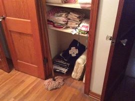 Bottom of closet has additional blankets & other linens