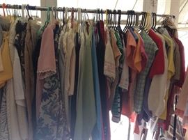 Four (4) racks of clothing, jackets, pants, blouses, & aprons. Most are small, petite small, medium