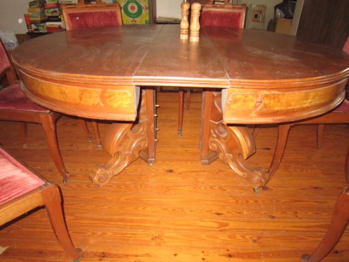 Large walnut dining table with 5 leaves and 6 chairs. Burl walnut panels on the apron