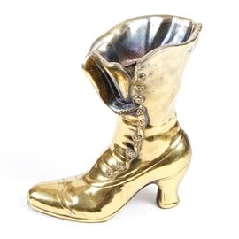 Metallic Boot Vase: A metallic boot vase. The metal vase is designed to resemble a women’s antique high-heeled boot. The piece has been spray painted gold and is unmarked.