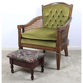 Velvet Armchair and Embroidered Footstool: A velvet armchair and embroidered footstool. The occasional chair features a cedar semi-gloss finish to its wooden frame, a button back seat with green velvet upholstery, and tapered legs that end in square feet. The arms have woven rattan accents. The footstool features a cherry finish, floral embroidery, and a storage compartment.