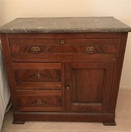Gray marble top antique three door chest used as a nightstand. 39 inches wide by 17 inches deep by 29 inches high. Wash Stand-style.