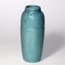 Slender Rookwood Vase: A slender blue Rookwood vase. The vase features a matte finish and a “spade” band just below the vase opening. The Rookwood flame logo is stamped on the base. The piece is dated 1919, style 2411. There is an additional marking “3405” on the base as well.