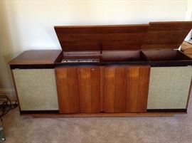 This view shows the speakers on each end.  The doors fold from the outside in and smoothly lay against the middle cabinets with protector buttons.  Notice they are finished on both sides. Also, the center compartment holds the receiver and the turntable.  The compartment on the right is empty.