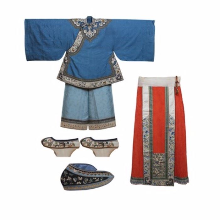 Antique Imperial Chinese Robes with Letter of Provenance: A set of antique Imperial Chinese robes. The blue silk tunic features a cloud embroidered motif, with a white appliqué border and collar having scenic fauna embroidery with black piping edge and mother of pearl shank buttons, and has a matching headpiece. The light blue pant article features an embroidered T-fret and auspicious symbol motif with contrast border at hem. The horse-hoof platform silk shoes are embellished with butterfly and floral embroidery. The pleated silk jacquard skirt has a decorative front panel with an embroidered country scene. These items were purchased from a descendant of Anson Burlingame, Ambassador to China during President Lincoln’s administration, in 1945 and stored in a cedar chest for 40 years. They have since been professionally restored and kept in a custom-made protective cabinet. Includes a framed letter of provenance written by Clive Burlingame’s wife.