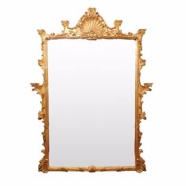 Antique French Provincial Style Large Gold Wall Mirror: A large, antique French Provincial style wall mirror. This large, gilt framed mirror features a shell motif crest and foliate border with several flat levels.