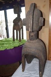 This impressive and superb wooden shoulder mask comes from the Baga people.  This is a classical example that displays many traditional components such as the spherical head, the plaited hair with medial crest, a large noses and pendulous breasts which hang close to the body,  its four legs, and geometric patterns decorating the hairstyle and the breast . This mask depicts a bust of a woman on four legs. Such mask is known as a D'mba headdress, that is by far the most well known Baga work of art. Its use was documented as early as 1886.  It represents an older woman who has given selflessly, and also represents community. It is worn on the head with a costume of raffia and cloth.

The Nimba masks, often monumental works carried on the shoulders, rank among the largest of all ritual objects in West Africa. Their use, as hinted at above, is rather ubiquitous. They are used at funerals, harvest festivals, and at initiations. Normally these "masks" have four legs or posts (for placement on
