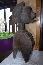 This impressive and superb wooden shoulder mask comes from the Baga people.  This is a classical example that displays many traditional components such as the spherical head, the plaited hair with medial crest, a large noses and pendulous breasts which hang close to the body,  its four legs, and geometric patterns decorating the hairstyle and the breast . This mask depicts a bust of a woman on four legs. Such mask is known as a D'mba headdress, that is by far the most well known Baga work of art. Its use was documented as early as 1886.  It represents an older woman who has given selflessly, and also represents community. It is worn on the head with a costume of raffia and cloth.

The Nimba masks, often monumental works carried on the shoulders, rank among the largest of all ritual objects in West Africa. Their use, as hinted at above, is rather ubiquitous. They are used at funerals, harvest festivals, and at initiations. Normally these "masks" have four legs or posts (for placement on