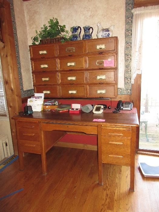 2 items here, an oak desk and a wall mounted 12 section storage cabinet. 