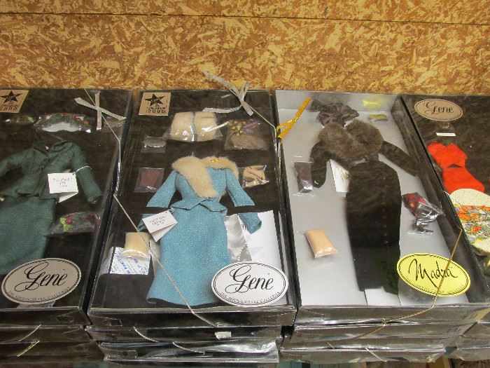 Dozens of doll clothing sets in box