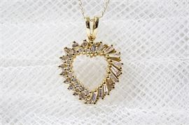 14K Yellow Gold Diamond Heart Pendant Necklace: A 14K yellow gold diamond heart pendant necklace. The pendant hangs by a split bale to a delicate 10K yellow gold 0.50 mm chain.