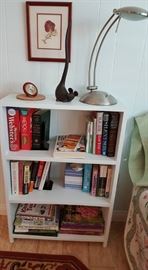 White bookcase with variety of books.