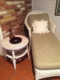 White wicker chaise lounge with round 2-tiered side table