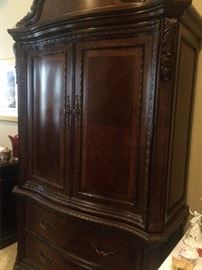 Large TV armoire matches the bed, nightstands, and dresser