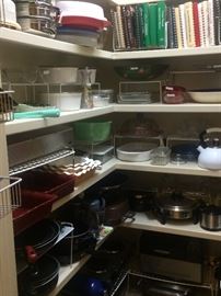 Large pantry filled with small appliances, corning, recipe books, and bakeware