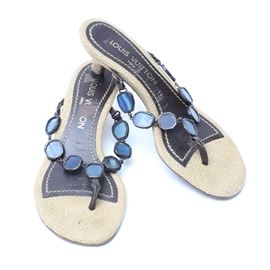 Louis Vuitton Kitten Heel Sandals: A pair of kitten heel sandals by Louis Vuitton, size 35.5. These sandals have a woven jute material on the heels and partial foot beds. The straps feature small circular sections of blue glass edged in a dark metal and chained together. The center of the straps and parts of the foot beds are a brown leather.