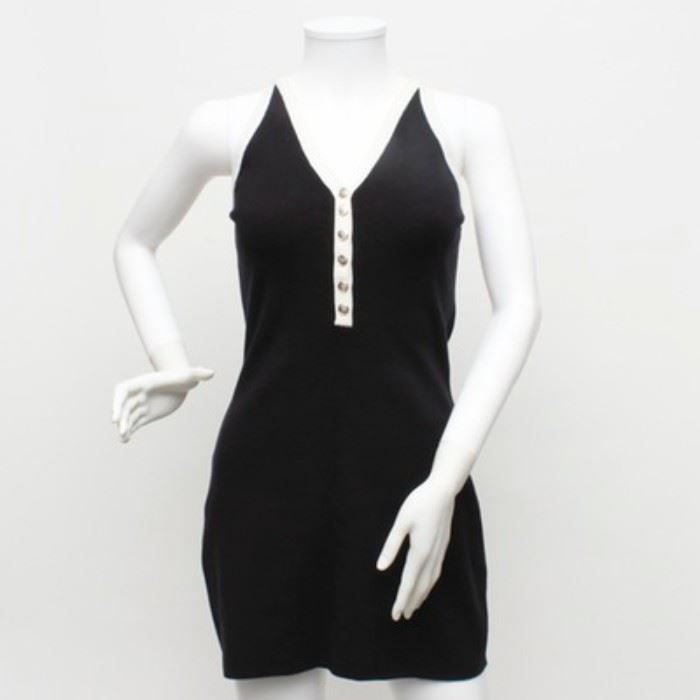 Dolce & Gabbana Maglie Black Sweater Dress: A black and white sweater dress by Dolce & Gabbana Maglie. This black sleeveless dress features white trim along the V-neckline which ends with a center set row of silver-tone buttons. It has a straight line high back and is a size 42.