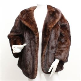 Mink Fur Coat: A mink fur coat. This coat has a brown mink exterior with a shawl collar. A satin type lining with a monogram “EBB” makes up the interior.