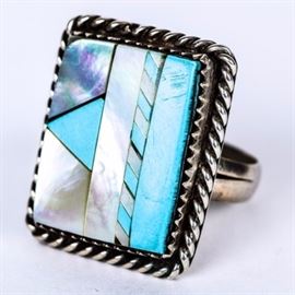 Sterling Silver and Inlaid Turquoise and Mother of Pearl Statement Ring: A sterling silver statement ring featuring a geometric turquoise and mother of pearl inlay in a saw-tooth bezel setting with a braided border on a split shank.