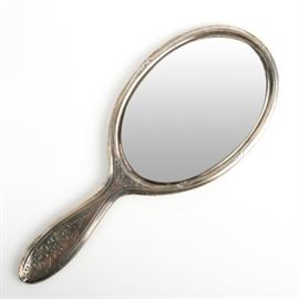 Vintage Tiffany & Co. Sterling Silver Hand Held Vanity Mirror: A vintage Tiffany & Co. sterling silver hand held vanity mirror featuring embossed scrollwork throughout with an etched monogram to the center. The tip of the mirror is marked “Tiffany & Co. 5167 Sterling” as well as “6883”.