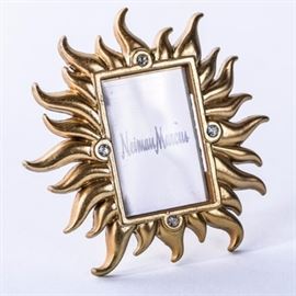 Jay Strongwater for Neiman Marcus Sunburst Frame: A petite gold tone sunburst picture frame from Neiman Marcus. It was designed by Jay Strongwater and features four flush set Swarovski Crystals to each side. The piece is marked “Jay Strongwater” to the verso and has a Neiman Marcus insert to the center. It has an alligator clip and collapsible stand.
