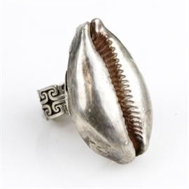 Sterling Silver Cowrie Shell Statement Ring: A sterling silver statement ring featuring a carved cowrie shell to the top, mounted on a Greek Key patterned openwork shank. This ring is a size 8 with a total approximate weight of 1.13 ozt. The interior is marked 925.