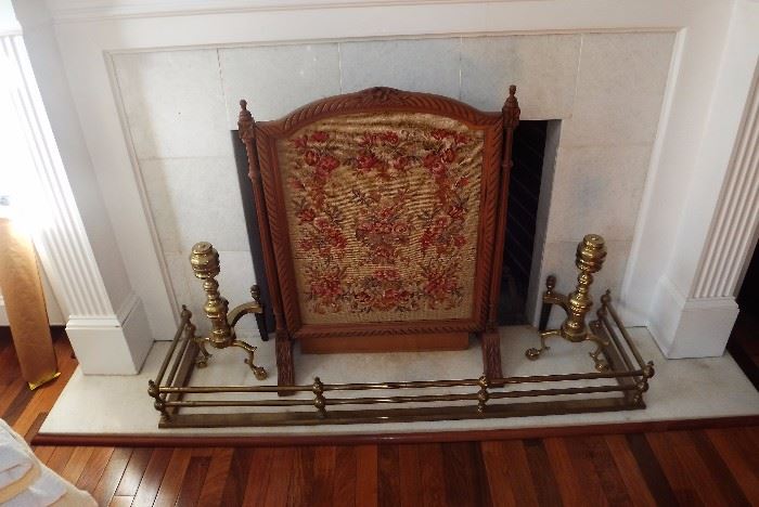 Needlepoint fireplace screen, brass andirons, and brass hearth fender