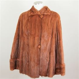 Summertime Ermine Fur Coat: A summertime ermine fur coat. This coat features a wing collar and cuff sleeves. It is lined with a green fabric tagged “Herman” lining.