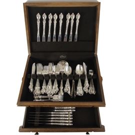 "Du Barry" Sterling Flatware Set by International Silver: An eight-place setting of sterling flatware by International Silver in the Du Barry pattern. Each piece has a molded handle featuring low relief floral decoration. This set includes eight butter knives, eight steak knives, ten butter knives, eight dinner forks, sixteen salad forks, eight cocktail forks, eight teaspoons, eight oval soup spoons, two casserole spoons, and two meat forks. All pieces are marked “International Sterling”, and the total weight excluding the knives is 90.65 ozt.