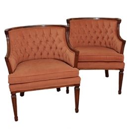 Pair of Upholstered Armchairs: A pair of upholstered armchairs. These chairs feature walnut veneer frames and a salmon upholstered turfed back and removable seat cushion. Each pair has tapered legs with carved detailing on square feet.
