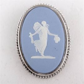 Wedgwood Jasperware Cameo and Sterling Brooch: A Wedgwood blue jasperware cameo and sterling brooch. This piece is oval in shape with a braided sterling frame, marked “Rainbow-Ster” on the back. The center cameo is made of power blue ceramic disk featuring a center white motif of a women, stamped “Wedgwood, Made in England”. The total weight including non-sterling components is 0.294 ozt.
