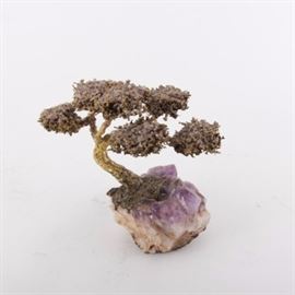 Amethyst and Metal Tree Sculpture: An amethyst and metal tree sculpture. This piece consists of a large chunk of amethyst with a metal tree attached on top. The bottom is lined by felt.