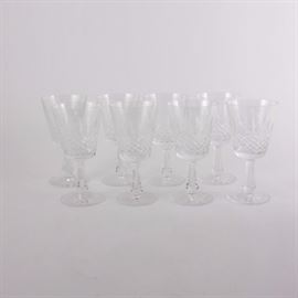 Waterford Crystal "Kenmare" Claret Wine Glasses: A set of eight Waterford Kenmare crystal claret wine glasses. Each glass features a cut crystal conical well, a hexagonal stem, and a round starburst pattern base. They bear the Waterford watermark on their undersides. Also included is a small crystal vase.