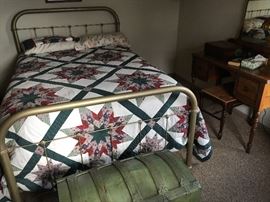antique iron bed and green trunk