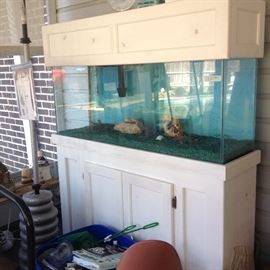Large aquarium in custom cabinet and a box of aquarium decor and supplies