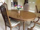 Dining room table with six upholstered chairs, two leaves and padding; measures 62Lx43W.  Each leaf measures 43-1/2L x 20W, adding 40 inches to length of the table.  Table and chairs have typical wear marks on the legs, otherwise all in very good condition. Chairs measure 43 in. tall. Manufactured by Henredon and purchased in 1977.