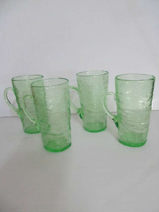 The Consolidated Glass Company was founded in 1926 in Coraopolis, Pennsylvania. In 1927 they introduced the Catalonian line, and this great auction has many, many of those very collectible pieces. 
This hand blown line is known for its distinctive look with bubbles, blisters, and inclusions intentionally left in the glass. 
This lot has four handled glasses, each 5.5" high. They are in great condition, ready to love. And, there are a total of 11 of these hard to find glasses (see the next 2 lots).