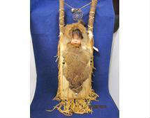 David Saice Papoose and carrier - hand painted porcelain head, buffalo fur hair, deer leather, rabbit fur, and glass beads. Signed "David Saice, #396, 5/12/95, ForeBears Trading Company". This doll measures approx. 28 in. without fringe.