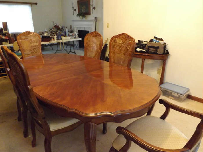 Nice dining table with 6 cane back chairs with fabric seats (one does have a very small hole - see pics - some of the others have a little stain here or there) just need cleaning. 2 chairs have arms (1 arm is loose on one of the chairs). The table has 2 leafs that are each 18" wide. In the pics the table does have one of the leafs in it (with that leaf the table is 82 1/4 x 44 1/2). The table also comes with pad protector. Great condition - very nice!!