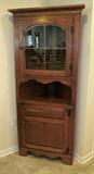 Very nice wood corner hutch in a maple finish with a top glass door. Also has grooves for plates. Measures 31W X 17D X 69H. In excellent condition.