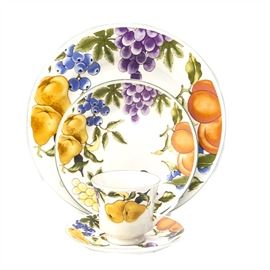 Sixteen Piece Set of Tabletops Unlimited Tableware: A sixteen piece set of Tabletops Unlimited tableware. Pieces are white in color with fruits such as pears, grapes, blueberries, and peaches featured on them. Included in the set are four dinner plates, four salad plates, four saucers, and four cups.