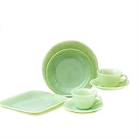 Thirty-Four Pieces of Jadeite Fire King Dishes: Thirty-four pieces of jadeite Fire King dishes. Included in the assortment are nine dinner plates in Jane Ray, two salad plates in Jane Ray, nine saucers in Jane Ray, Seven dinner plates in Charm, five saucers in Alice, one teacup in Alice, and one cup in Jane Ray, The Alice pattern features floral designs along the trump and around the cup. The Charm pattern features the square pattern of the plates. The Jane ray patterns have lines throughout the rims of the plates and cup.
