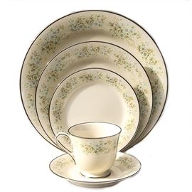 Thirty-Nine Piece Collection of Noritake Ivory China in Flower Maid: A thirty-nine piece collection of Noritake Ivory China in Flower Maid. The set includes nineteen dinner plates, ten saucers, nine bread plates, and one cup. The Flower Maid design features green yellow and blue flowers along each piece with a silver tone trim. Marking on the bottom of the pieces reads “Noritake Ivory China 7257 Flower Maid”.