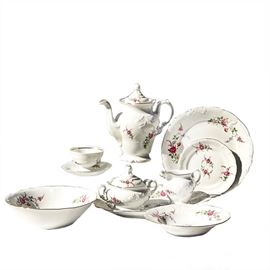 Thirty-Nine Piece Set of Royal Kent Poland China: A thirty-nine piece set of Royal Kent Poland china. The collection is marked with the Royal Kent emblem and labeled “Royal Kent Poland”. The pattern features a floral pattern with gold tone accents along the rims of the china pieces. The set includes one teapot, a cream and sugar set, one platter, one serving bowl, eight dinner plates, six teacups, eight saucers, four bread plates, and eight soup bowls.