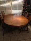 Very nice and solid oak pedestal table with 4 chairs.  Pedestal is carved and table has one large leaf (shown in photo) when removed, becomes a nice round table.