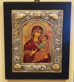 Lot 46: A contemporary hand-painted and sterling silver icon in the Byzantine style by Clarte. Depicting Mother of God within an ornate sterling and parcel gilt frame featuring two peacocks and crosses among a trailing grape vine, with hallmarks. Original certificate adhered to the reverse. The image and silver are in good condition; the frame has small chips to each corner. 7 1/4 x 8 3/4" high overall. ESTIMATE $200-300