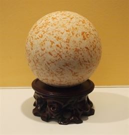 Lot 94: A decorative stone orb. Unpolished with red mottled appearance, raised on a separate Chinese stand. Good condition. 4" diameter; 5 3/4" high overall. ESTIMATE $40-60