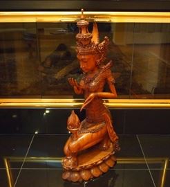 Lot 61: A contemporary Indonesian wood figure. Carved as a kneeling goddess with flame balanced on her knee, atop a lotus base. Two very small and minor nicks to the tip of the flame; otherwise, good condition. 11 3/4 x 28 1/4" high. ESTIMATE $100-200
