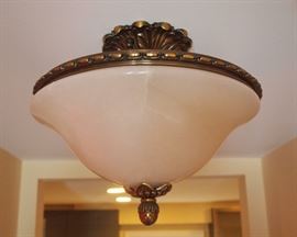 Lot 48: An alabaster and patinated metal ceiling fixture. Dome shape with pineapple finial. Approximately 13" diameter. Good condition. ESTIMATE $200-300